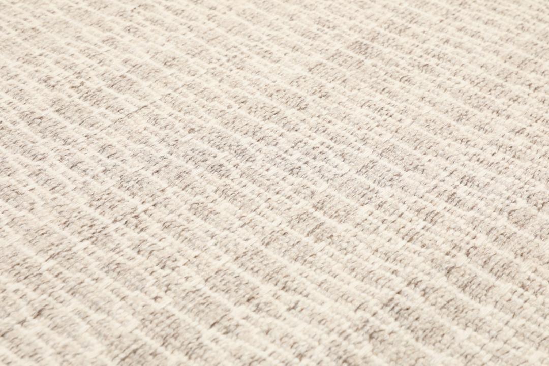 Beige tæppe med et struktureret vævet mønster