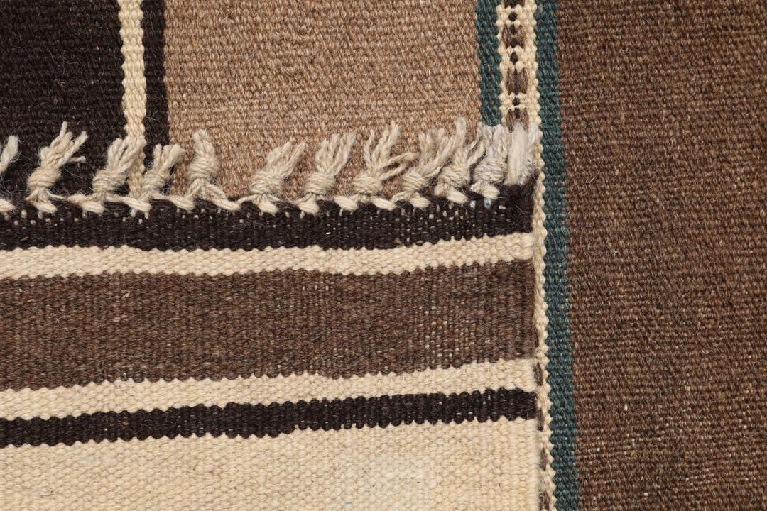 Håndvævet Kelim-tæppe fra Mellemøsten i nuancer af brun og beige med et stribet mønster.