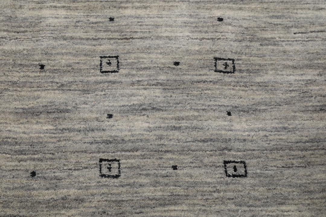 Tapete cinzento de lã com detalhe de rebordo subtil