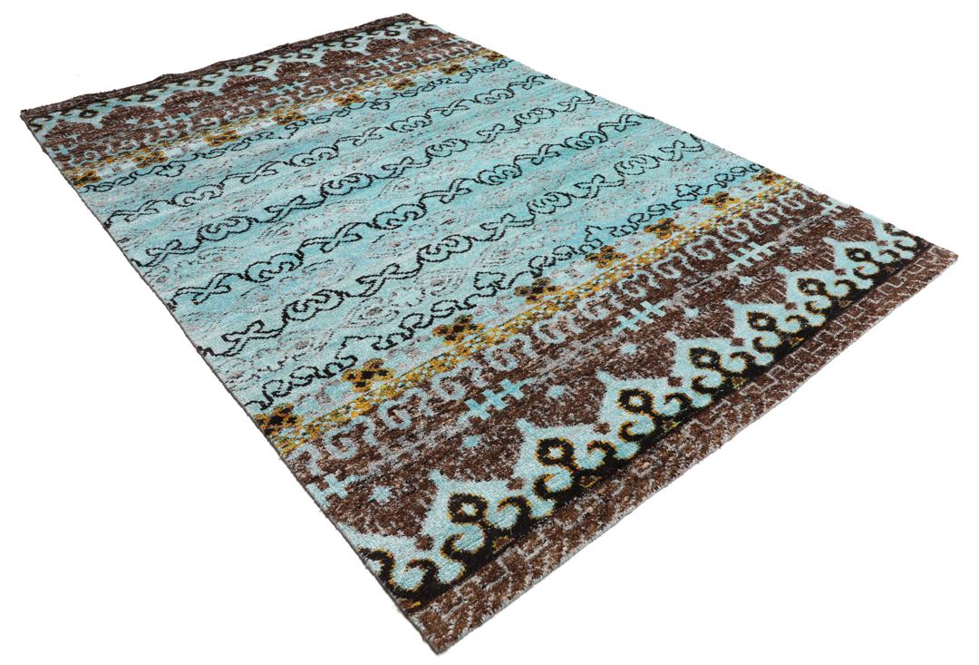 Tapis bleu clair noué main avec des motifs tribaux complexes