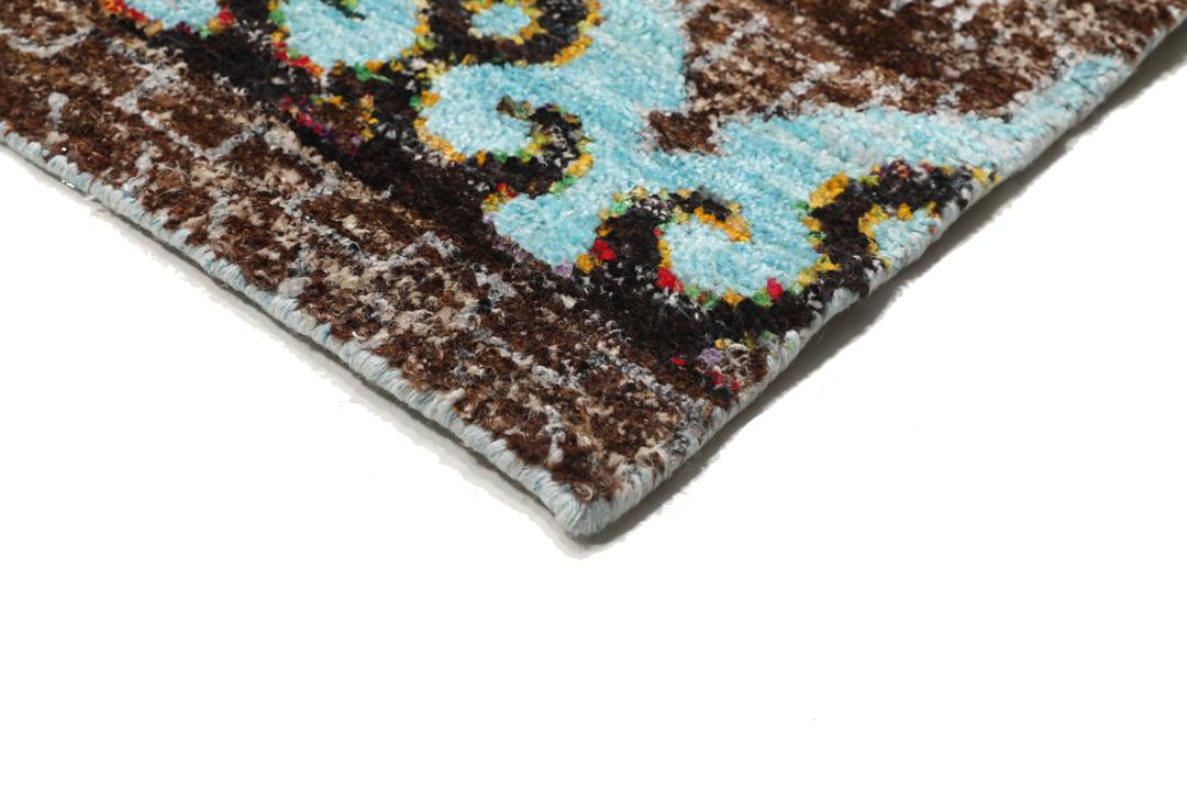 Tapis bleu clair noué main avec des motifs tribaux complexes