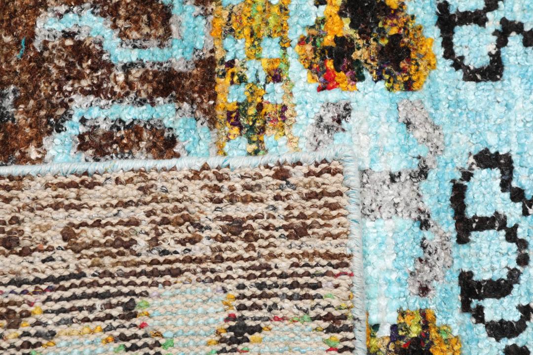 Tapis bleu clair noué main avec des motifs tribaux complexes