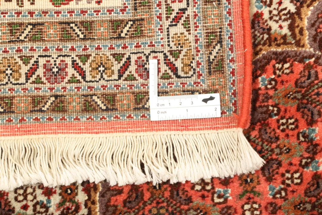 Et stort håndknyttet Tabriz-tæppe fra Mellemøsten i dybe røde og beige nuancer.