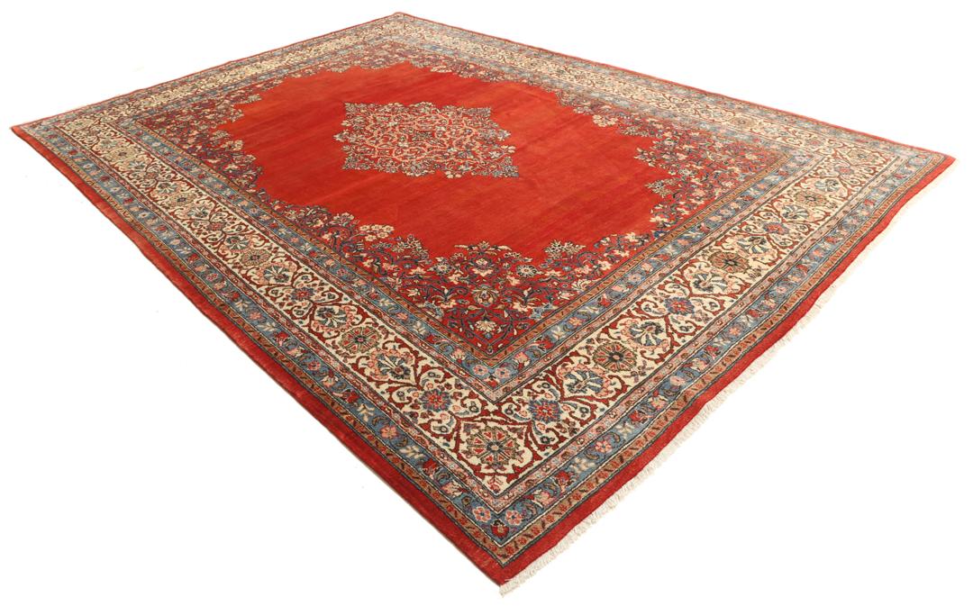 A hand-knotted Sarough rug from the Middle East featuring a red field and intricate floral medallion.