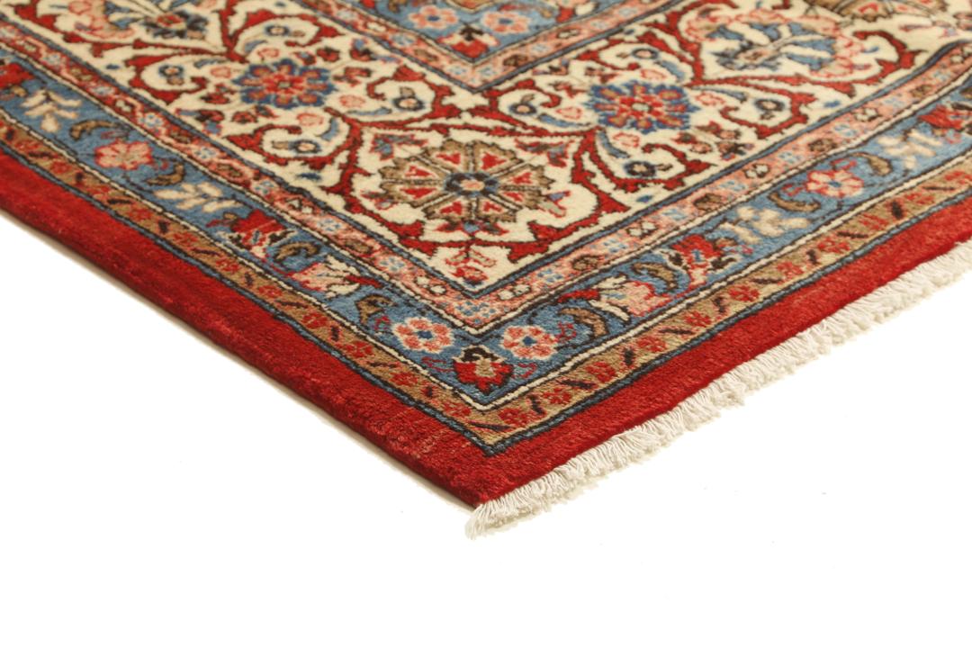 A hand-knotted Sarough rug from the Middle East featuring a red field and intricate floral medallion.