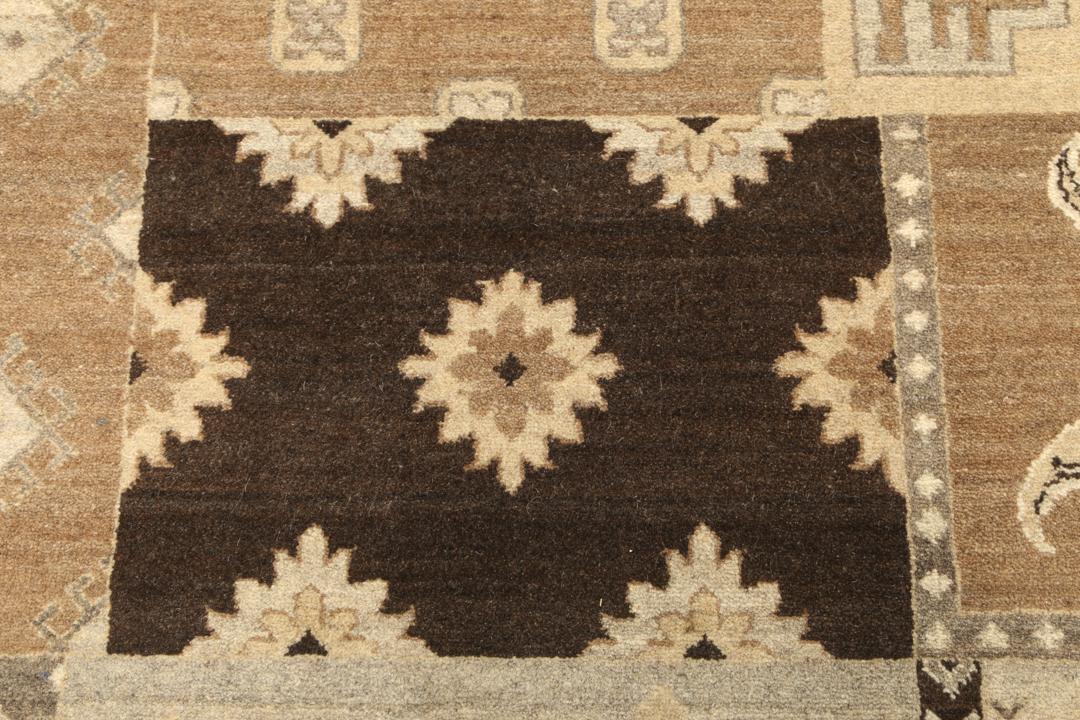 Et stort rektangulært håndknyttet moderne tæppe fra Indien med et brunt patchwork-design og forskellige geometriske mønstre.