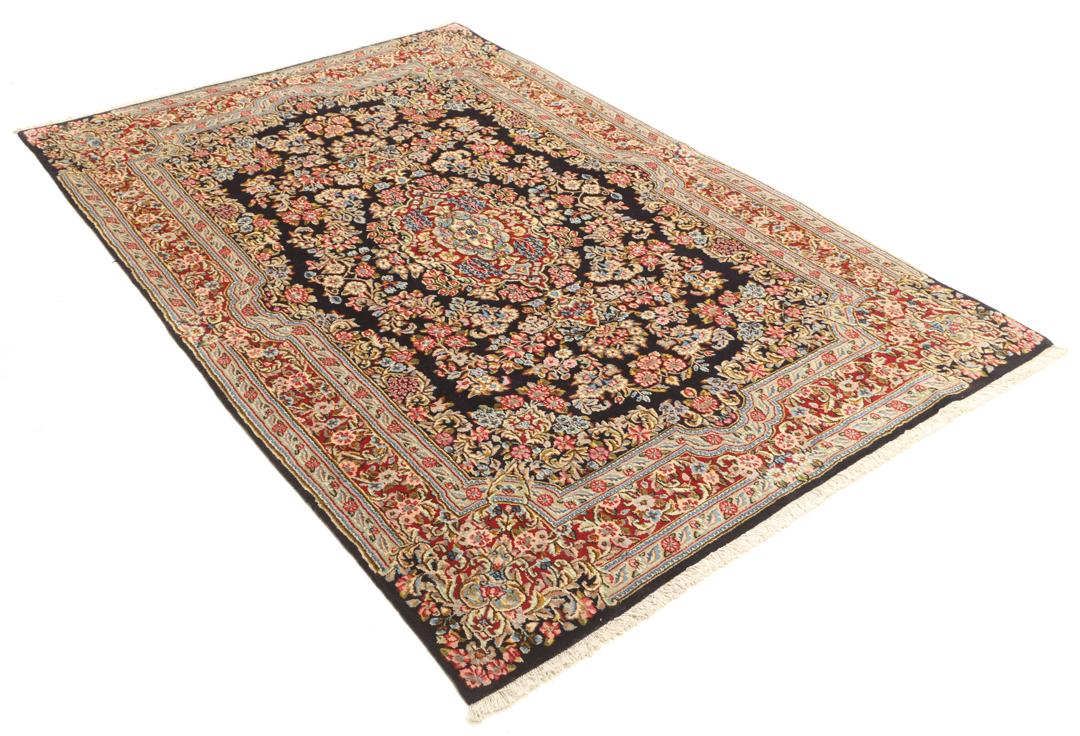 Een handgeknoopt Kerman-tapijt uit het Midden-Oosten met een diepblauw veld en bloemmotieven