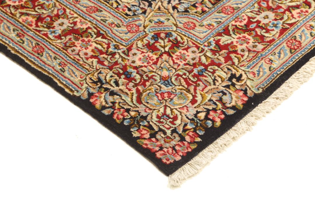 Een handgeknoopt Kerman-tapijt uit het Midden-Oosten met een diepblauw veld en bloemmotieven