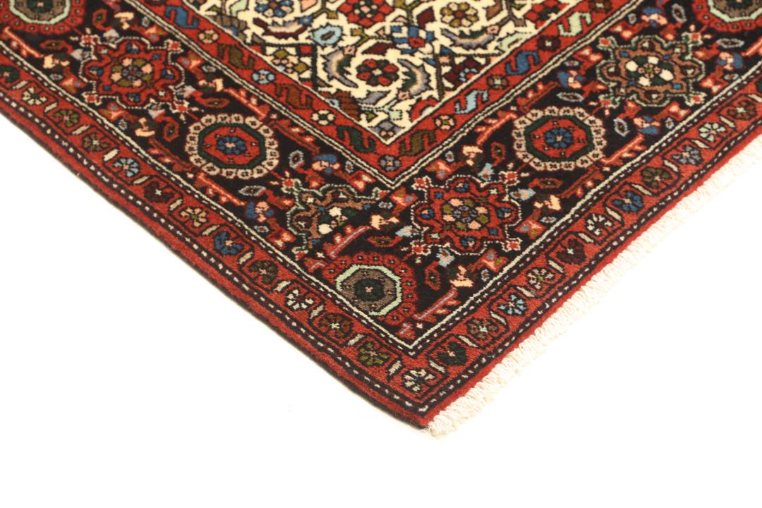 Een handgeknoopt Gholtogh-tapijt uit het Midden-Oosten met een levendig rood en beige medaillonontwerp.