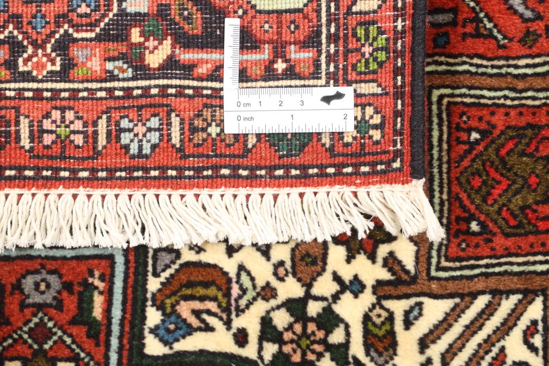 Een handgeknoopt Gholtogh-tapijt uit het Midden-Oosten met een levendig rood en beige medaillonontwerp.