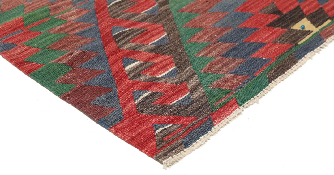 Tapis Kelim turc tissé à la main avec un motif géométrique vibrant en rouge, vert et noir.
