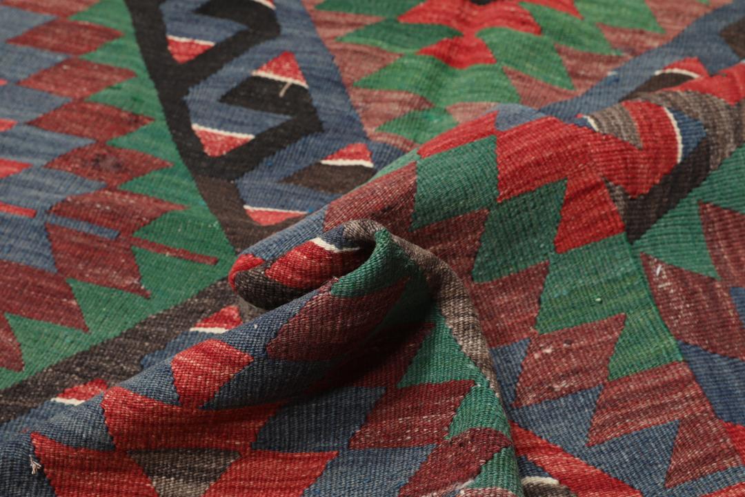 Tapis Kelim turc tissé à la main avec un motif géométrique vibrant en rouge, vert et noir.