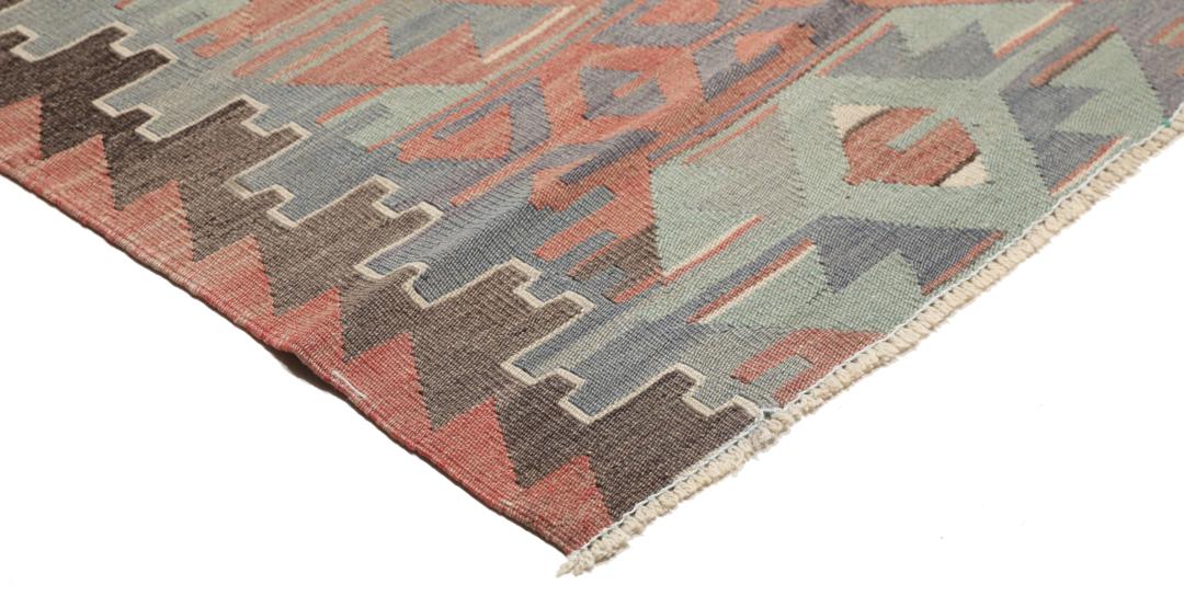 Et vintage tyrkisk Kelim-tæppe med geometriske mønstre i en flerfarvet palette af rød, blå og brun.
