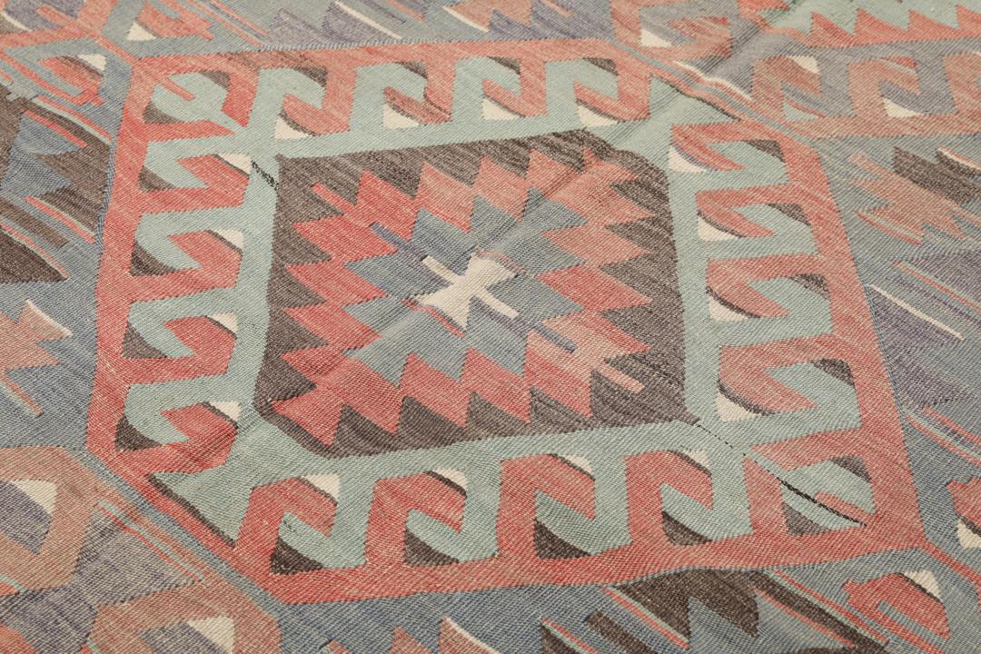Et vintage tyrkisk Kelim-tæppe med geometriske mønstre i en flerfarvet palette af rød, blå og brun.