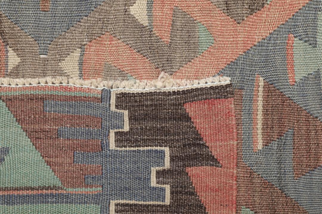 Et vintage tyrkisk Kelim-tæppe med geometriske mønstre i en flerfarvet palette af rød, blå og brun.