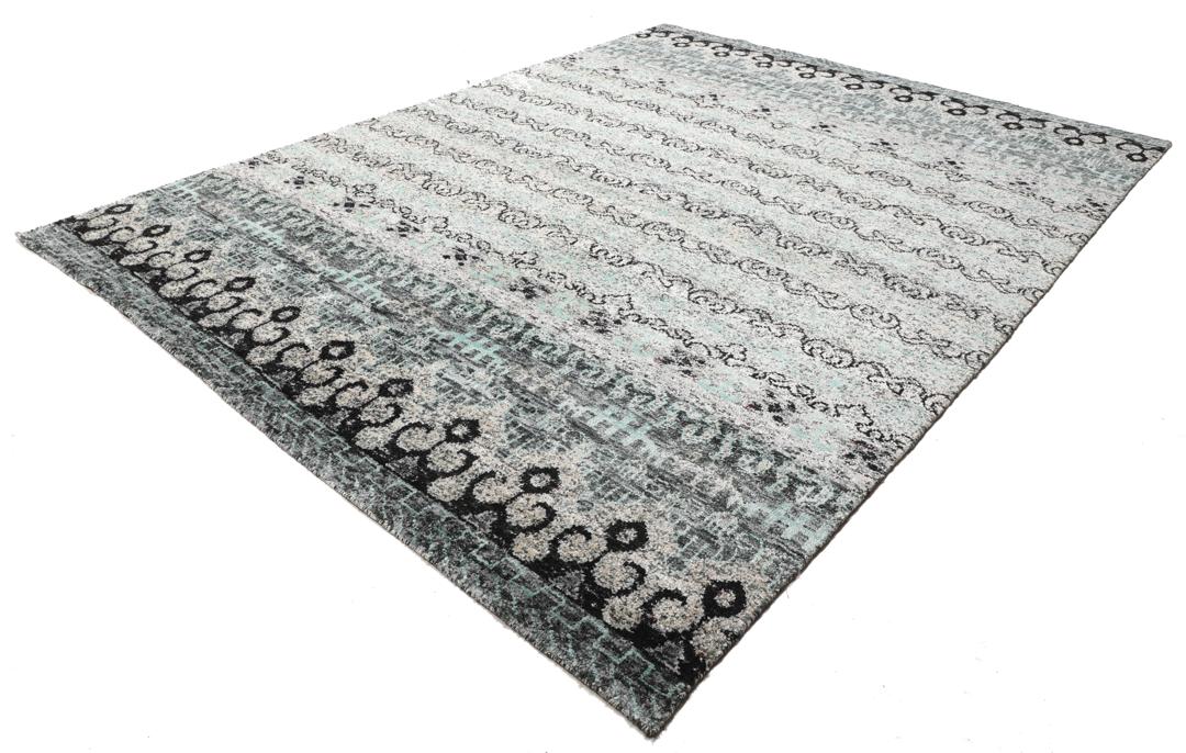 Un tapis gris sophistiqué avec des motifs complexes et un velours en soie douce.