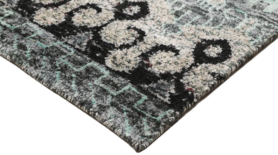 Un tapis gris sophistiqué avec des motifs complexes et un velours en soie douce.