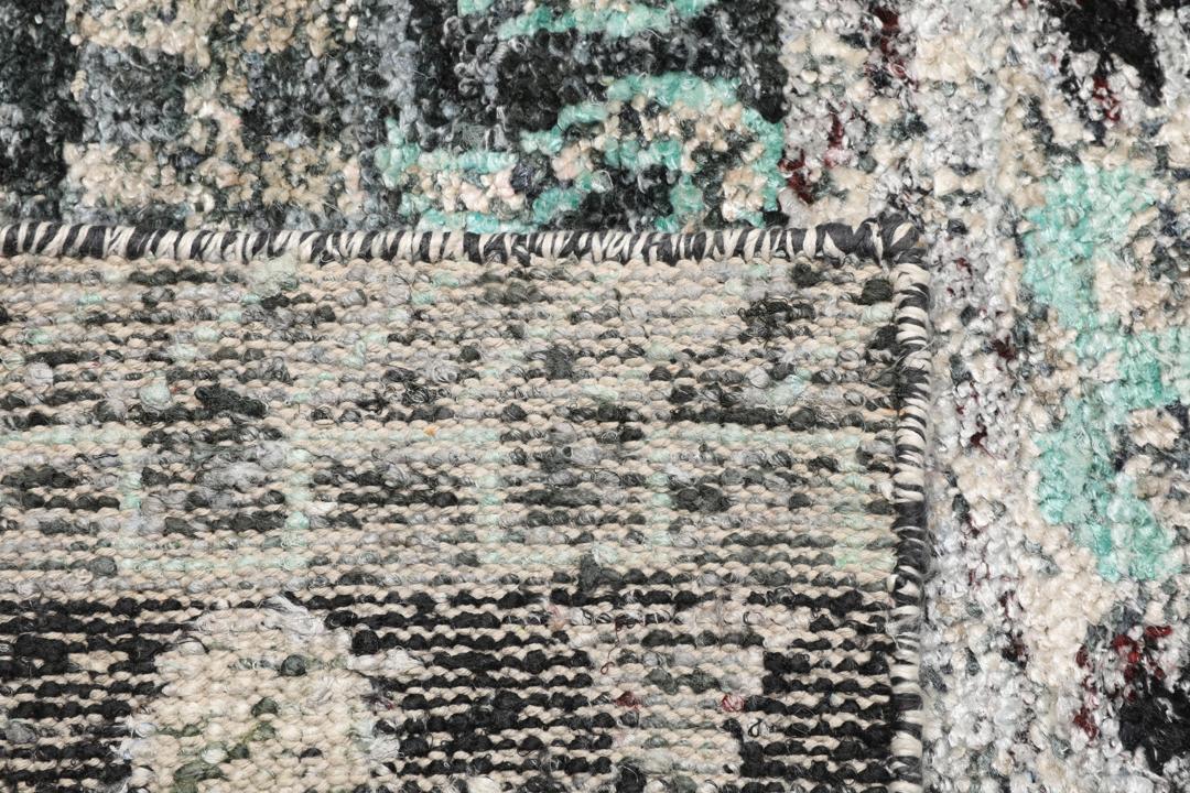 Un tapis gris sophistiqué avec des motifs complexes et un velours en soie douce.
