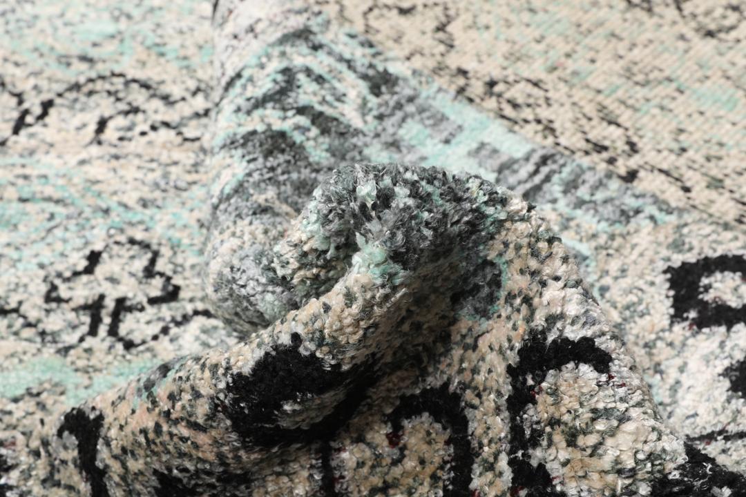 Un tapis gris sophistiqué avec des motifs complexes et un velours en soie douce.