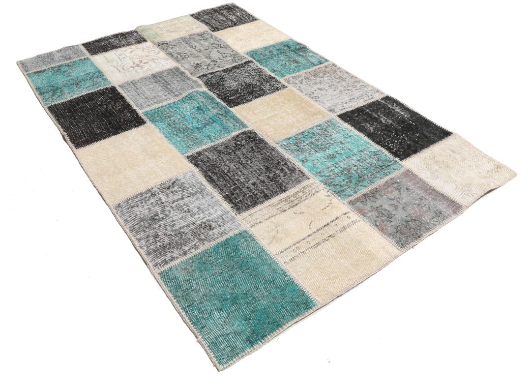 Et rektangulært patchwork-tæppe fra Tyrkiet med et flerfarvet geometrisk design.