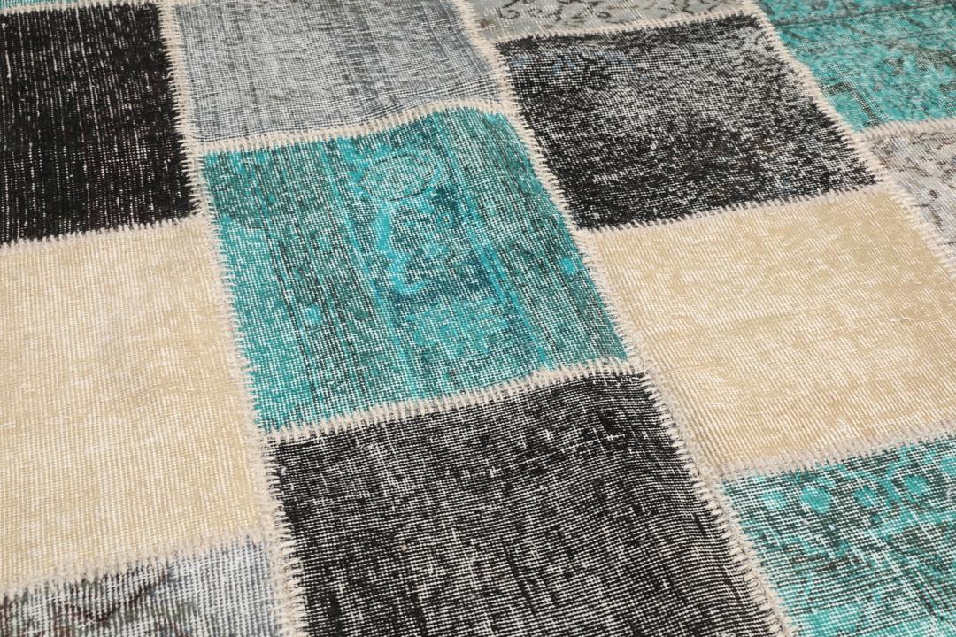 Et rektangulært patchwork-tæppe fra Tyrkiet med et flerfarvet geometrisk design.