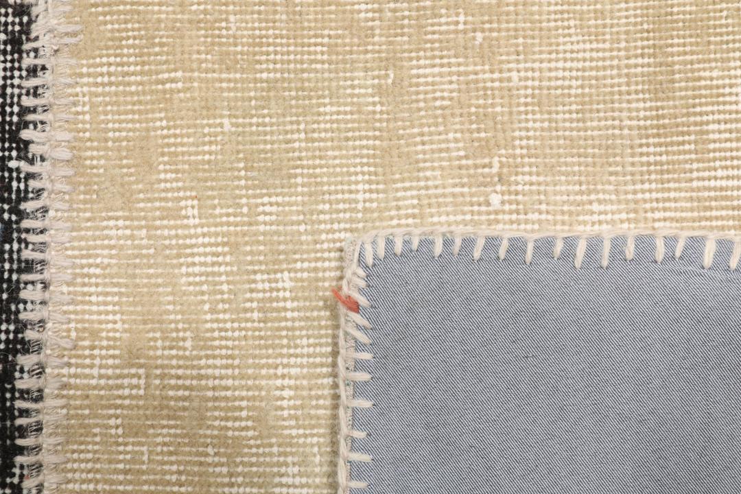 Et rektangulært patchwork-tæppe fra Tyrkiet med et flerfarvet geometrisk design.