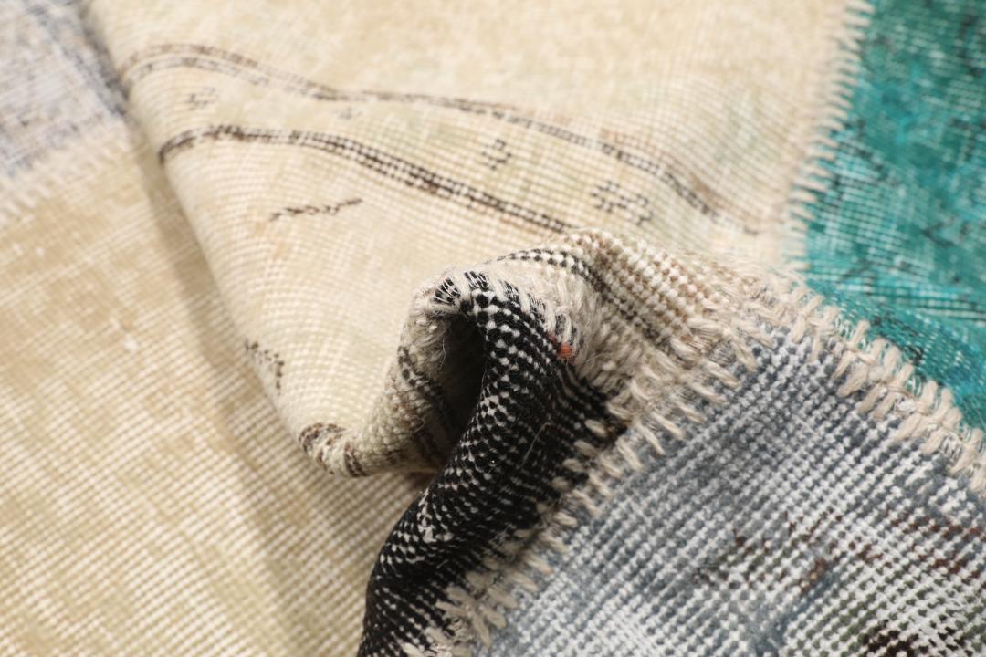 Et rektangulært patchwork-tæppe fra Tyrkiet med et flerfarvet geometrisk design.