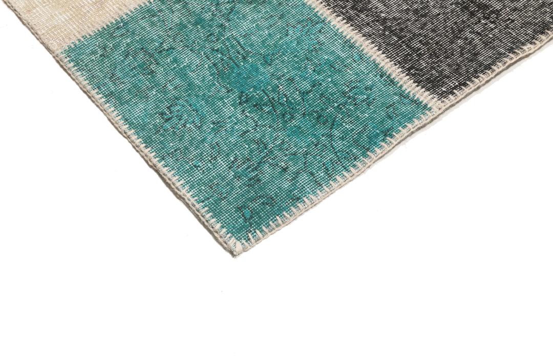 Et rektangulært patchwork-teppe fra Tyrkia med en flerfarget palett inkludert blågrønt og grått.