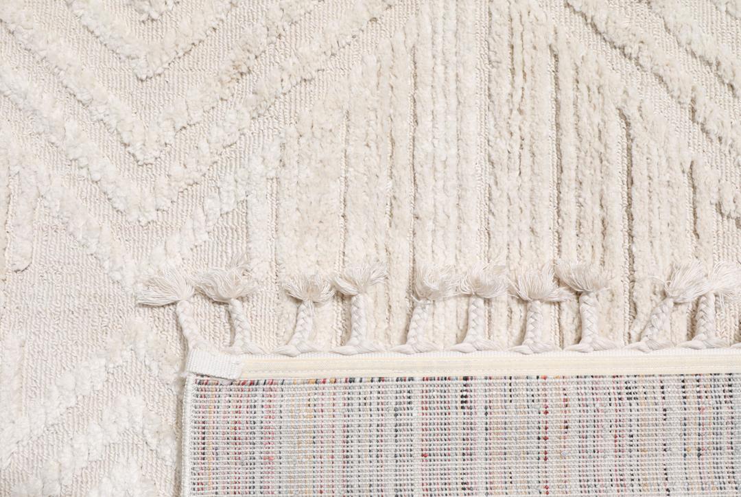 Cream white rug with diamond relief pattern and fringe detail