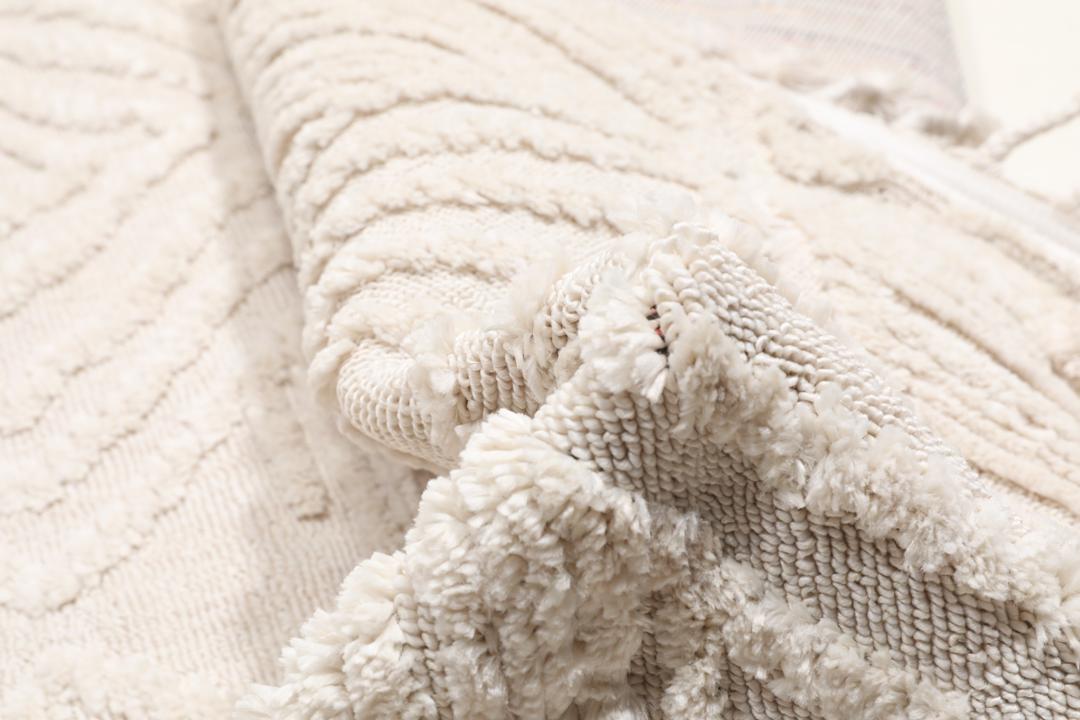 Cream white rug with diamond relief pattern and fringe detail