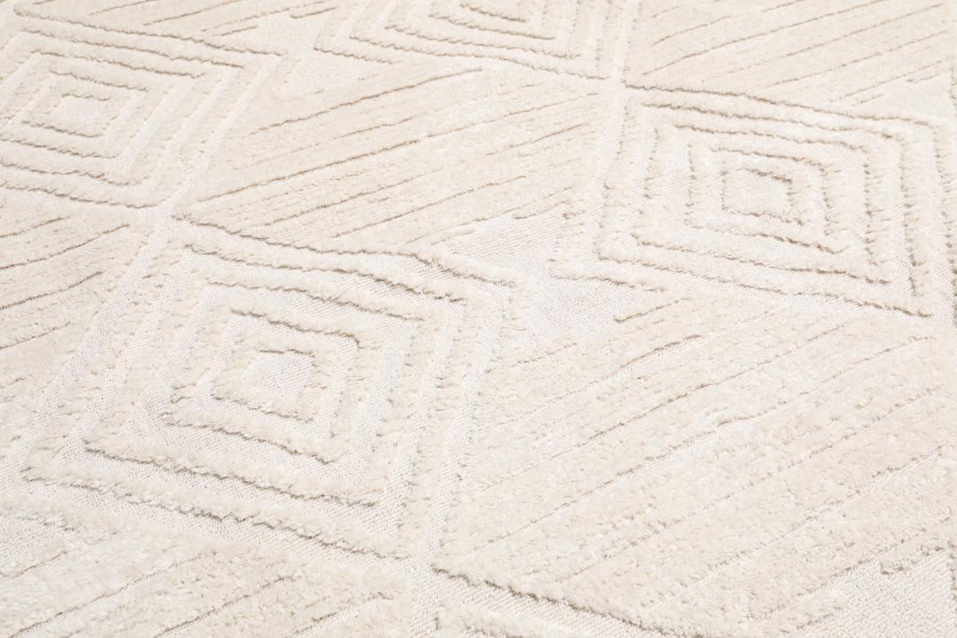 Cream white rug with diamond relief pattern and fringe detail