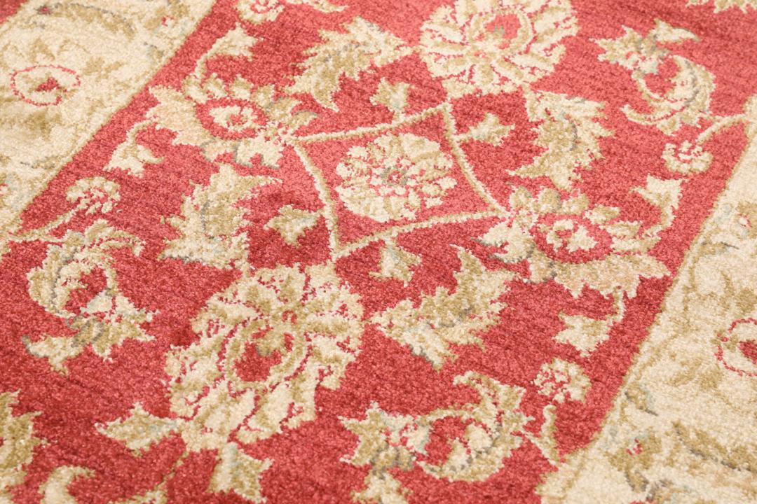 Rød løber med traditionelle blomstermotiver og dekorative kanter