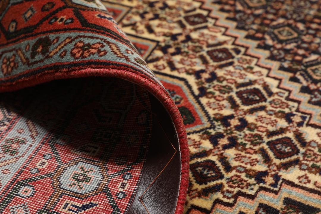 Handgeknoopt Senneh-tapijt uit het Midden-Oosten met een rood en blauw medaillonontwerp