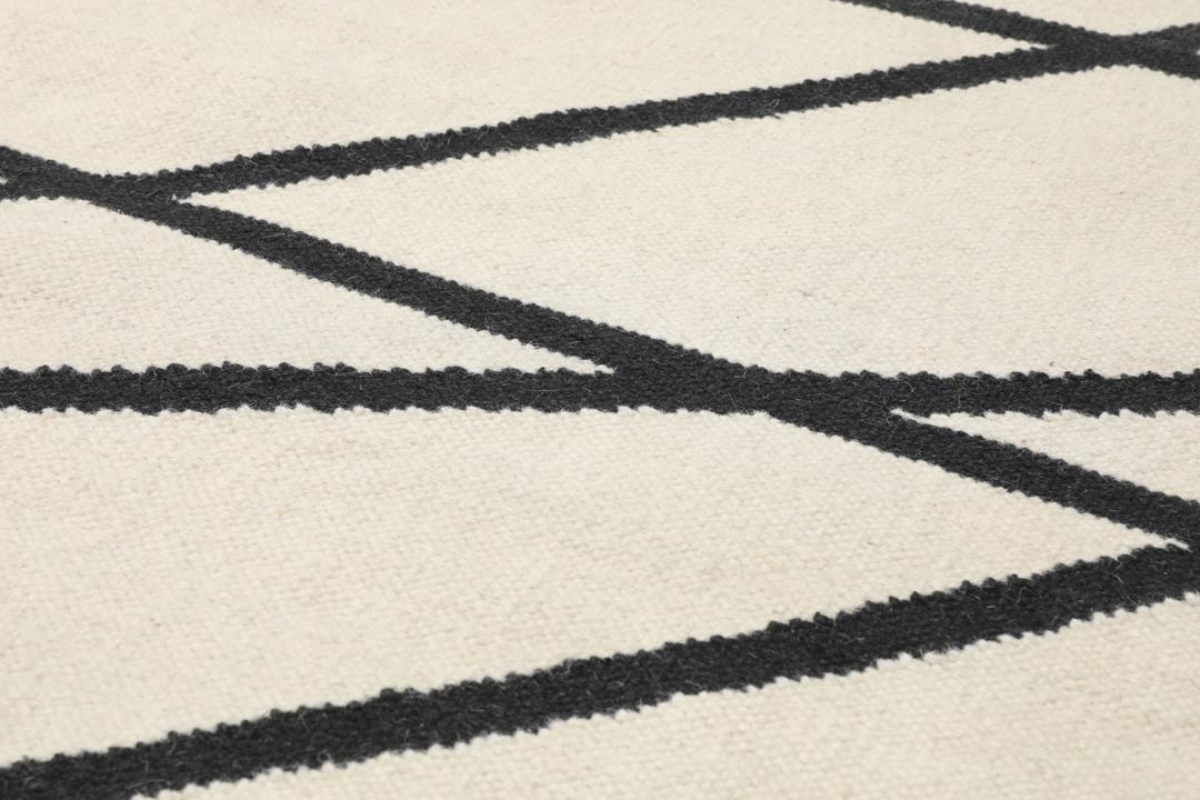 Handgeweven loper met een zwart lineair patroon op een gebroken witte achtergrond
