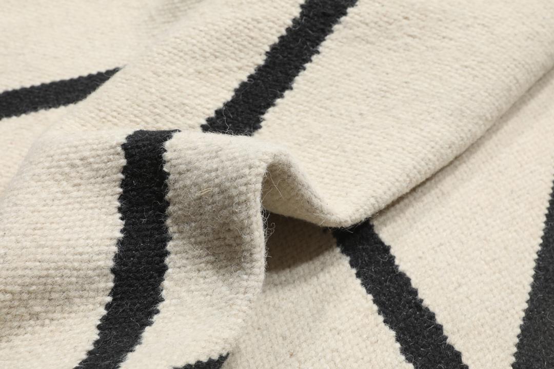 Handgeweven loper met een zwart lineair patroon op een gebroken witte achtergrond