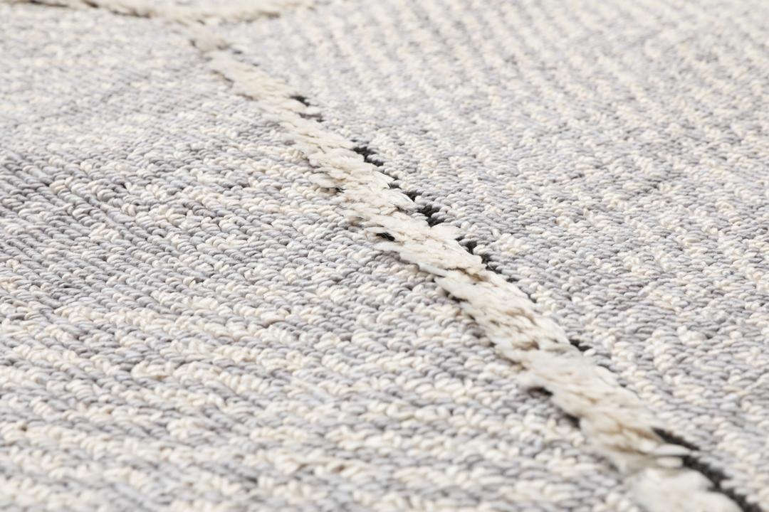 Lysegrå løber med et struktureret geometrisk mønster og frynsedetaljer