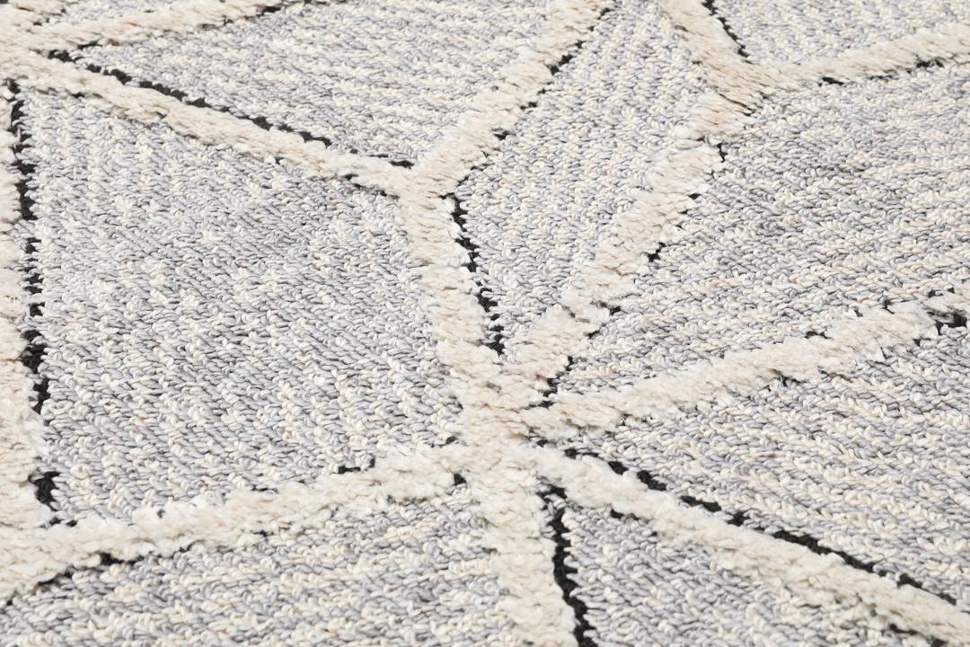 Lysegrå løber med et struktureret geometrisk mønster og frynsedetaljer