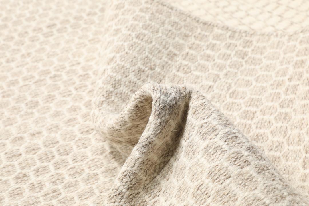 Beige handgeweven wollen tapijt met een subtiel honingraatpatroon