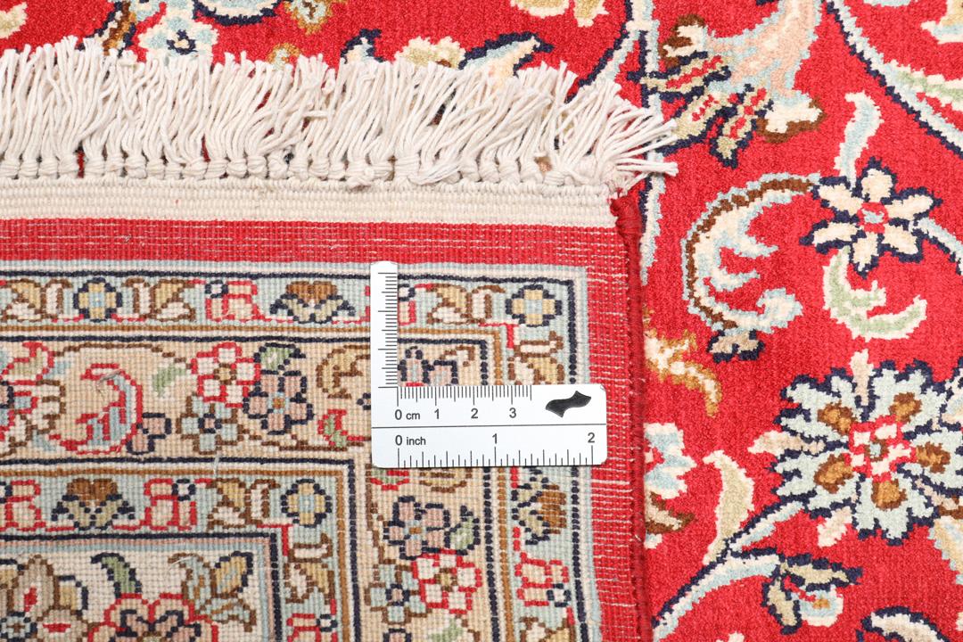 Et detaljeret rektangulært Kashmir-silketæppe fra Indien med et levende rødt blomsterfelt og dekorative kanter.
