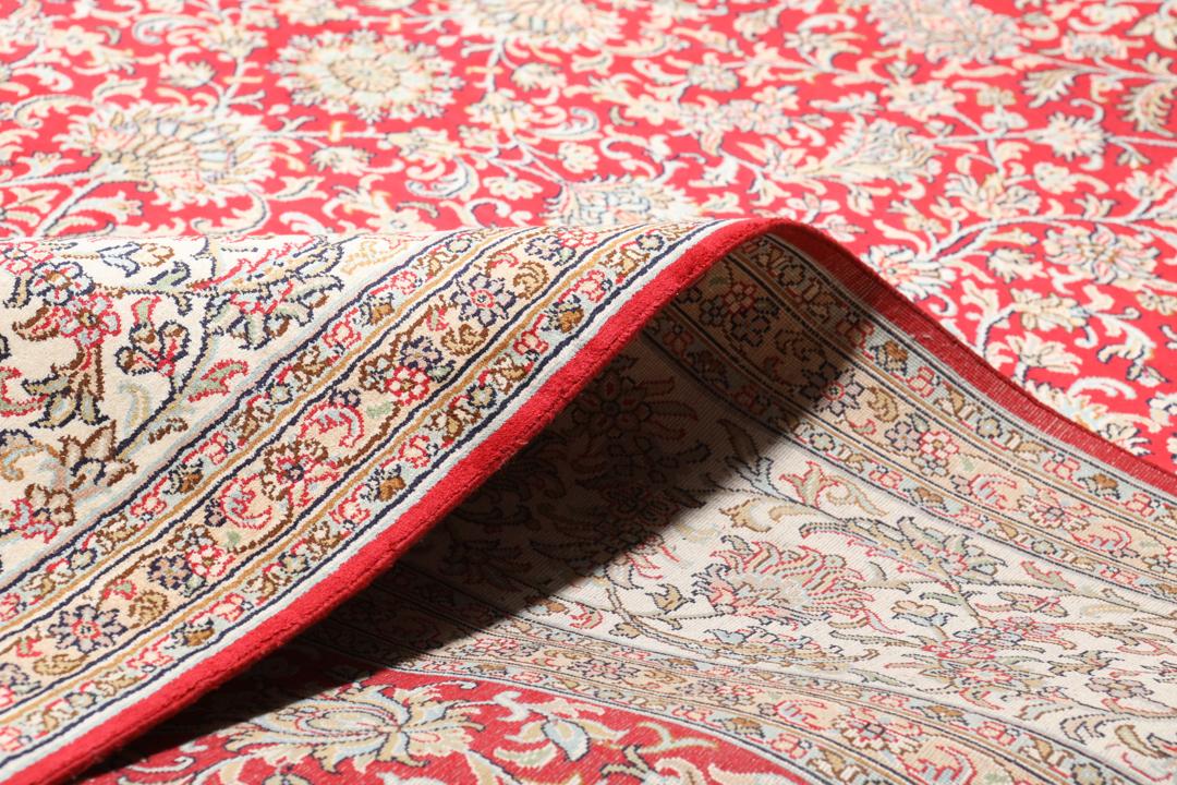 Et detaljeret rektangulært Kashmir-silketæppe fra Indien med et levende rødt blomsterfelt og dekorative kanter.
