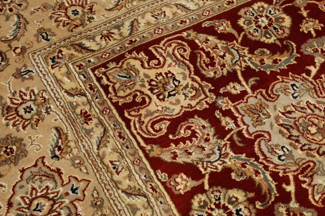 Ręcznie wiązany dywan Tabriz z Indii z bogatym czerwonym tłem i misternymi kwiatowymi wzorami w kolorze beżu i kremu
