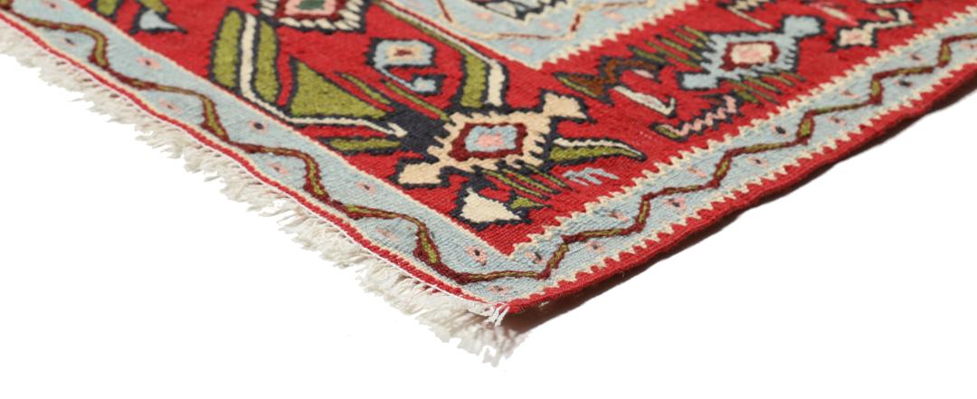 Handgeweven Kelim Senneh-tapijt uit het Midden-Oosten met een rood en blauw geometrisch patroon.