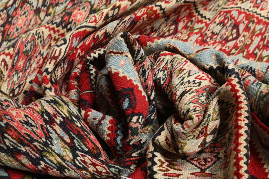 Handgeweven Kelim Senneh-tapijt uit het Midden-Oosten met een rood en blauw geometrisch patroon.