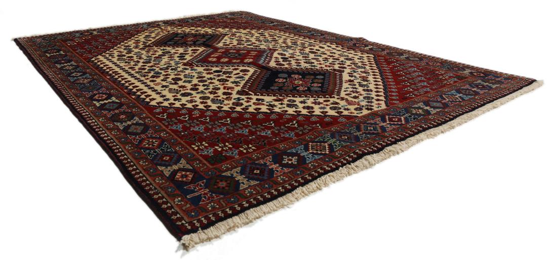 Een handgeknoopt Yalameh-tapijt uit het Midden-Oosten met een levendig rood en beige geometrisch ontwerp.