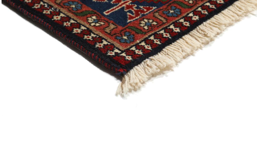 Een handgeknoopt Yalameh-tapijt uit het Midden-Oosten met een levendig rood en beige geometrisch ontwerp.