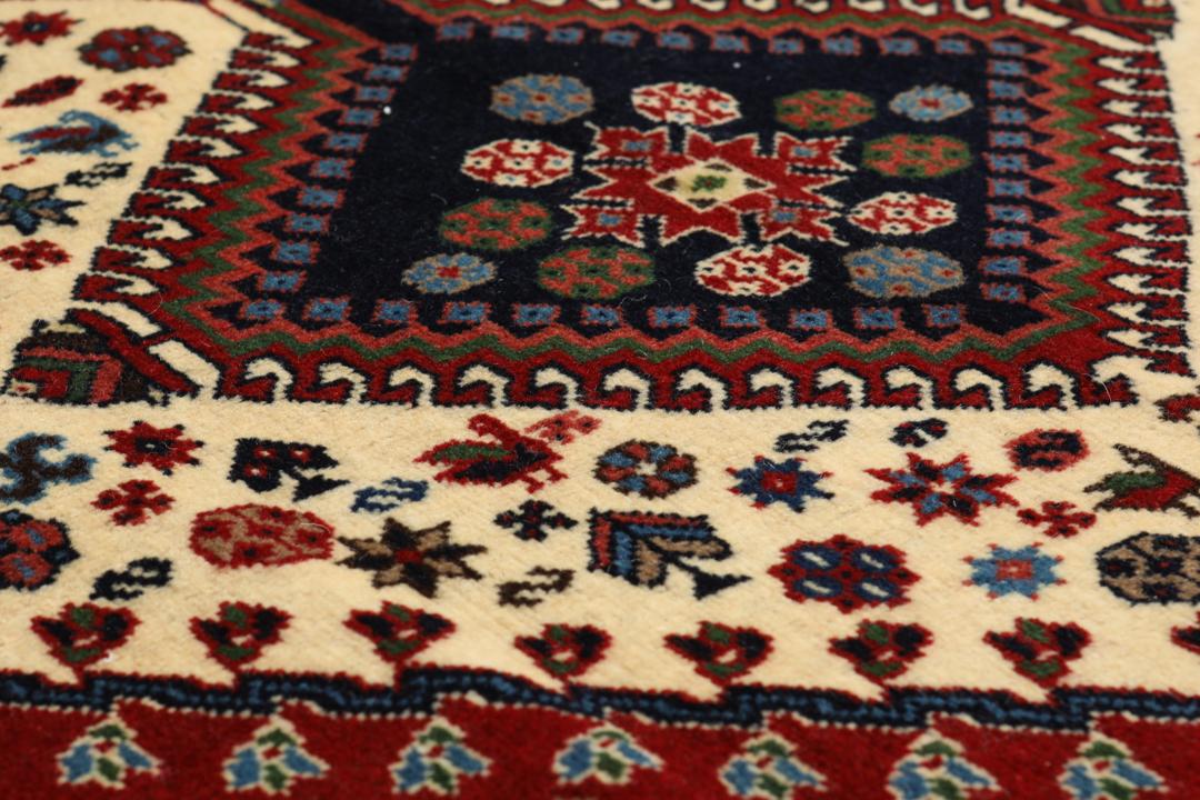 Een handgeknoopt Yalameh-tapijt uit het Midden-Oosten met een levendig rood en beige geometrisch ontwerp.