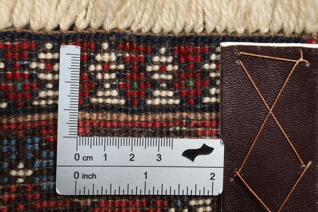 Een handgeknoopt Yalameh-tapijt uit het Midden-Oosten met een levendig rood en beige geometrisch ontwerp.