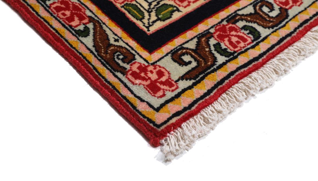 A hand-knotted Senneh rug from the Middle East featuring a vibrant red and black colour palette.