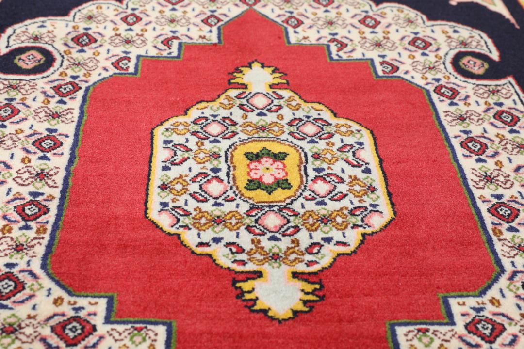 A hand-knotted Senneh rug from the Middle East featuring a vibrant red and black colour palette.