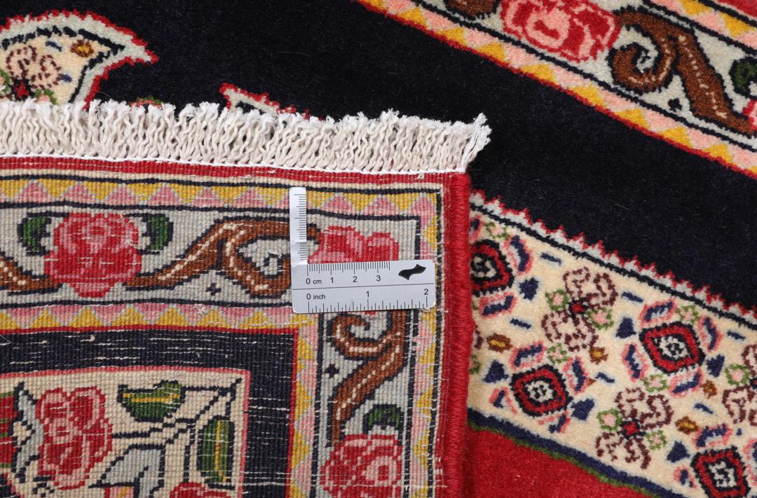 A hand-knotted Senneh rug from the Middle East featuring a vibrant red and black colour palette.